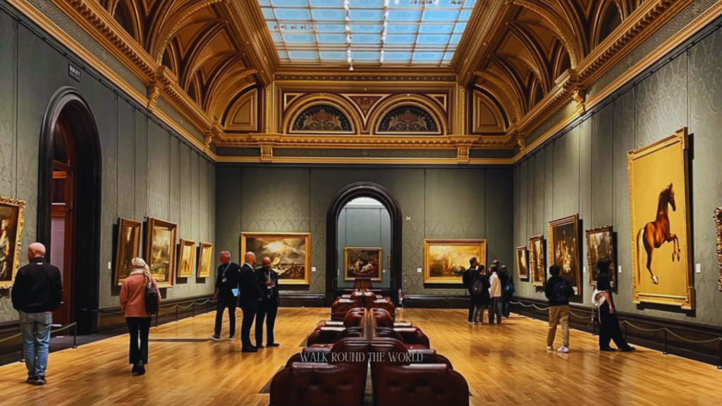 Main hall inside National Gallery London with visitors and artworks