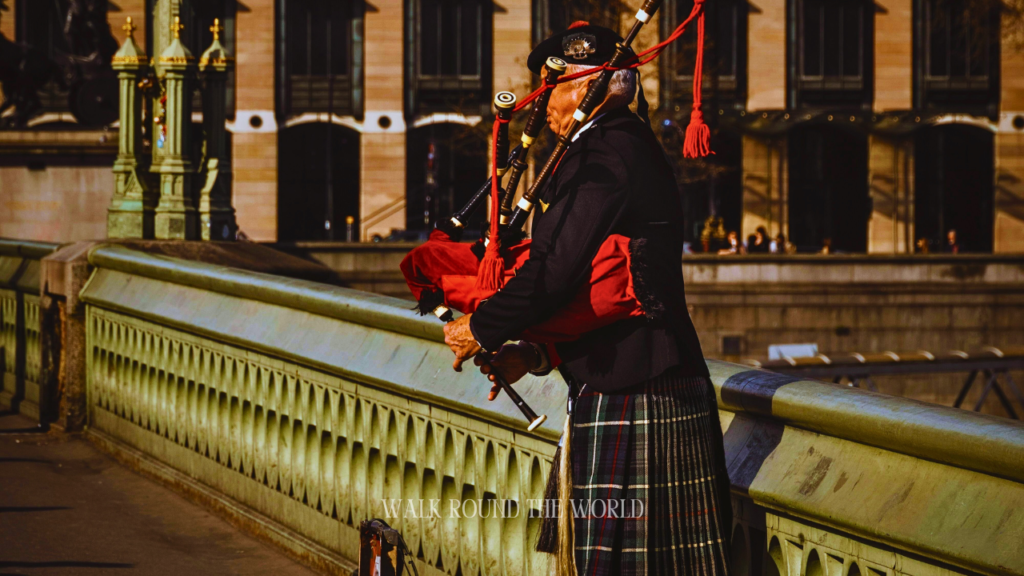 Scottish bagpiper playing bagpipe on Westminster Bridge