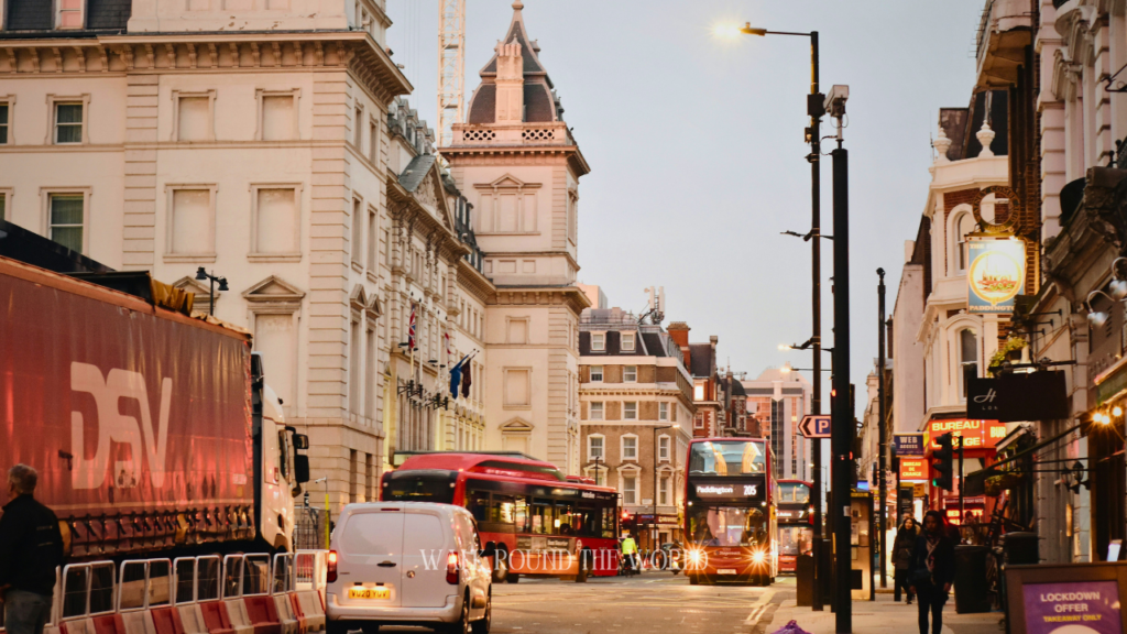 Praed Street near Paddington Station in London with red buses and evening city traffic
