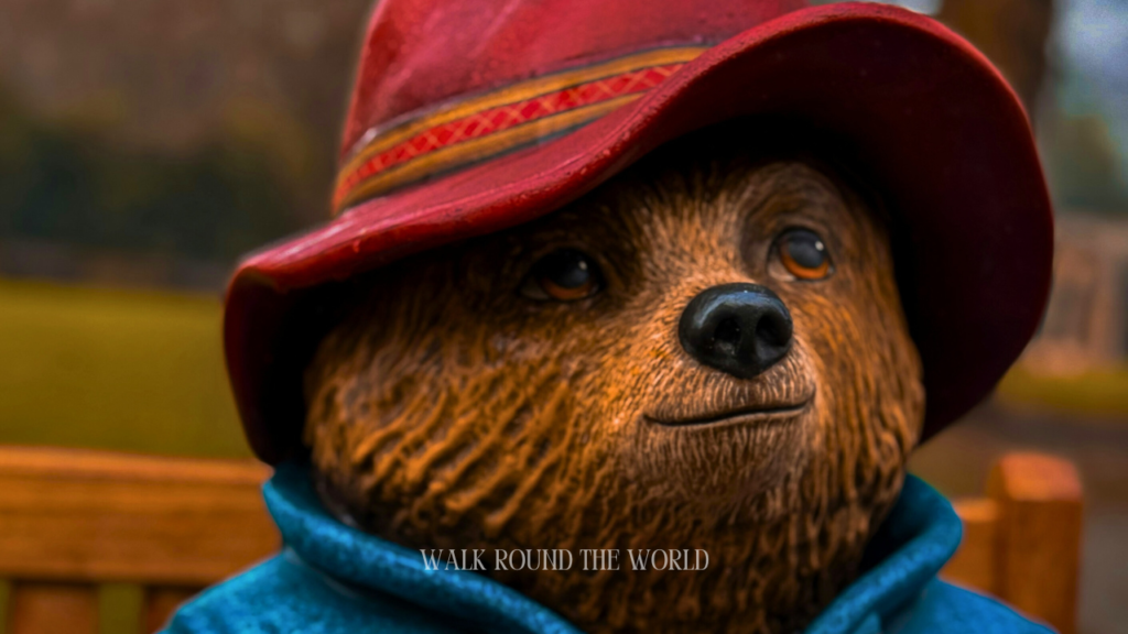 Paddington bear statue sitting on a bench outside paddington station in London