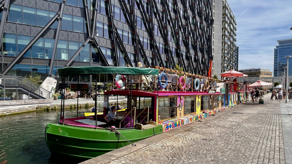 Colorful houseboat café at Little Venice near Paddington with people enjoying canal-side dining in London
