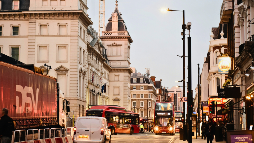 Red double decker bus on a busy street in Paddington London with cars and city traffic