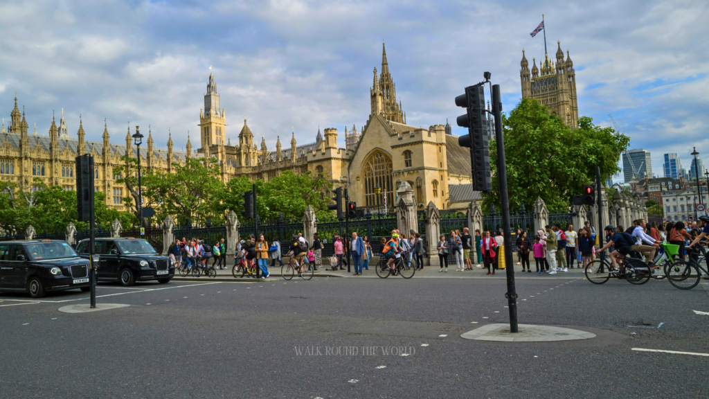 Pedestrians and cyclists crossing the road near the Houses of Parliament in Westminster London