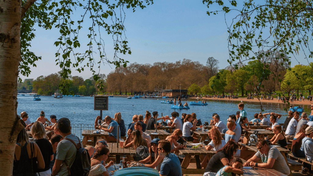 People relaxing on the grass in Hyde Park London during summer