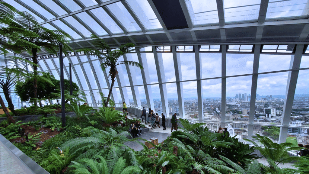 Tourists inside Sky Garden London overlooking the city before sunset
