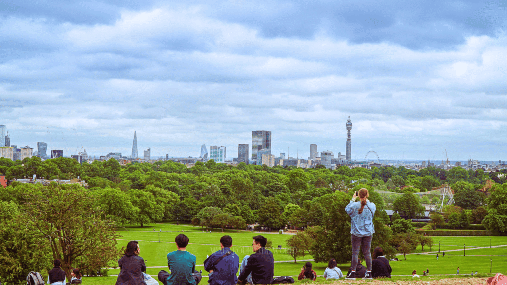 People watching sunset from Primrose Hill during a summer evening in London