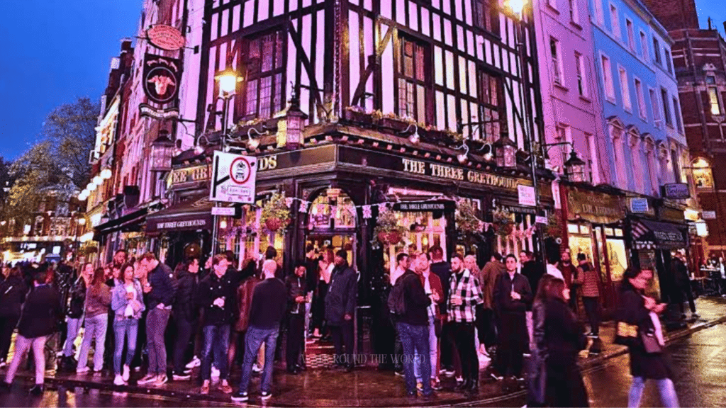Busy summer evening in Soho London with glowing neon lights