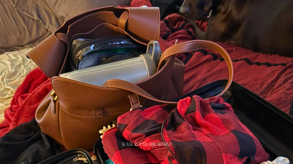 Open suitcase packed for a London summer trip with clothes and a day bag ready for travel
