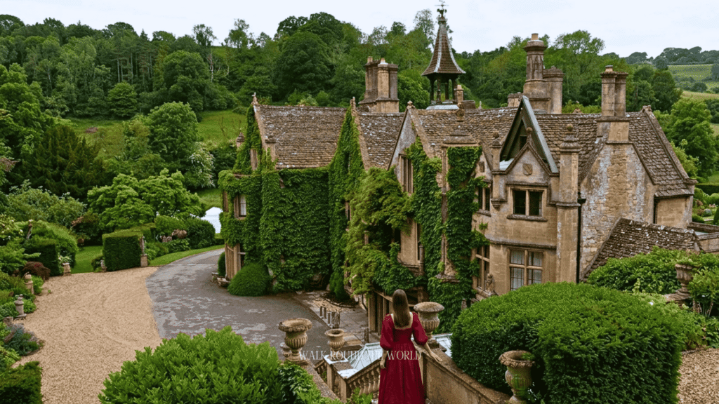A visitor overlooking a historic manor house surrounded by lush gardens and rolling countryside in the Cotswolds during a day trip from London.