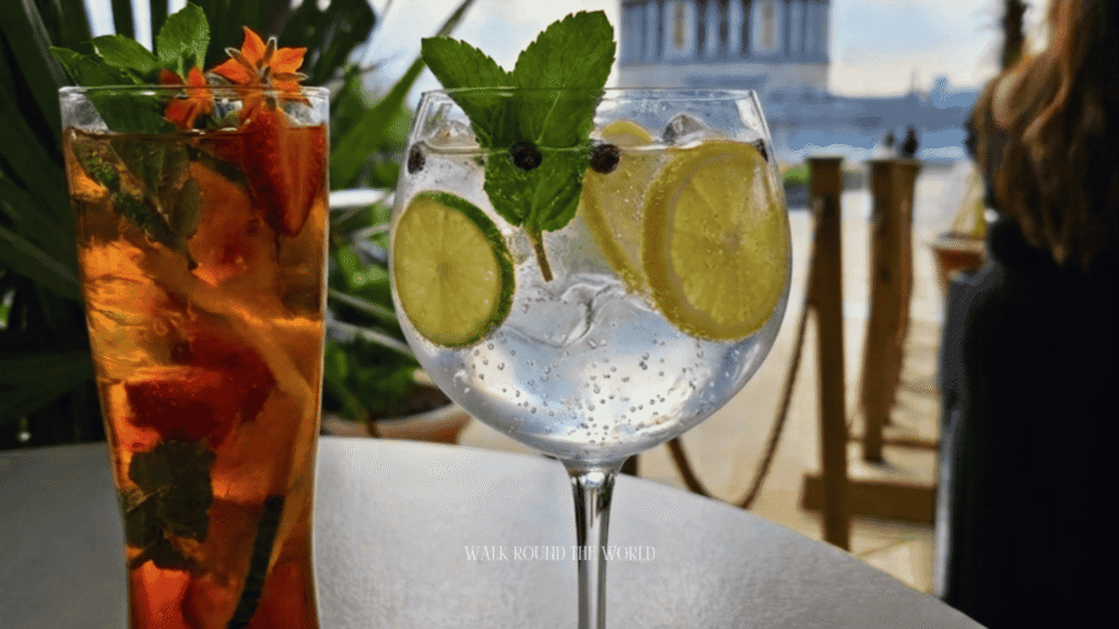 Refreshing summer cocktails served at Madison rooftop bar in London with views of St. Paul's Cathedral on a sunny afternoon.