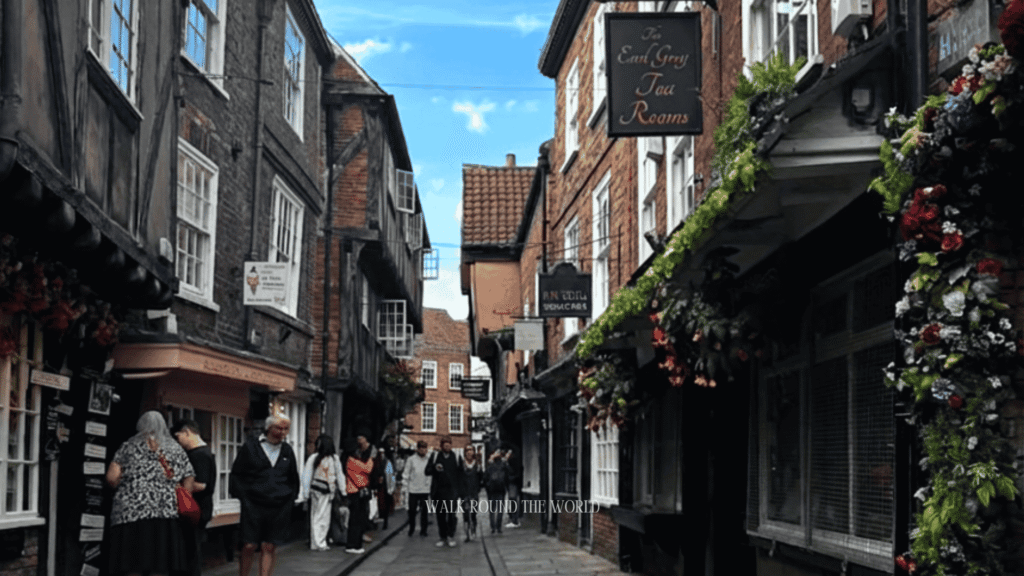 Visitors walking through The Shambles near The Earl Grey Tea Rooms in York, one of England's best-preserved medieval shopping streets and a popular day trip from London.