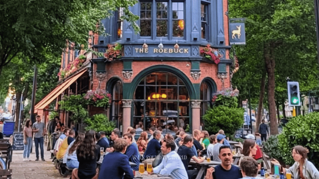 The Roebuck, a traditional London pub, on a sunny summer day with outdoor seating and visitors enjoying the warm weather.