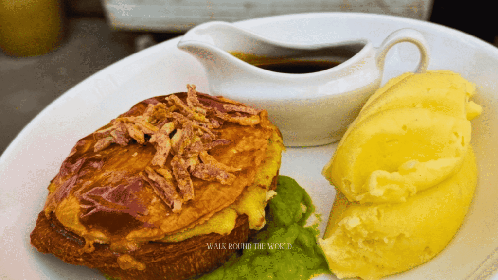 Traditional Steak and Ale Pie served with mashed potatoes and vegetables in a historic Central London pub.