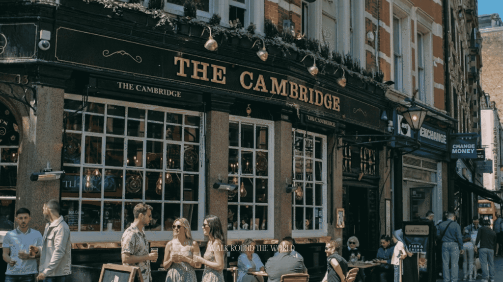 The Cambridge pub in London on a sunny summer afternoon, with visitors enjoying outdoor seating and the welcoming atmosphere of a traditional British pub.