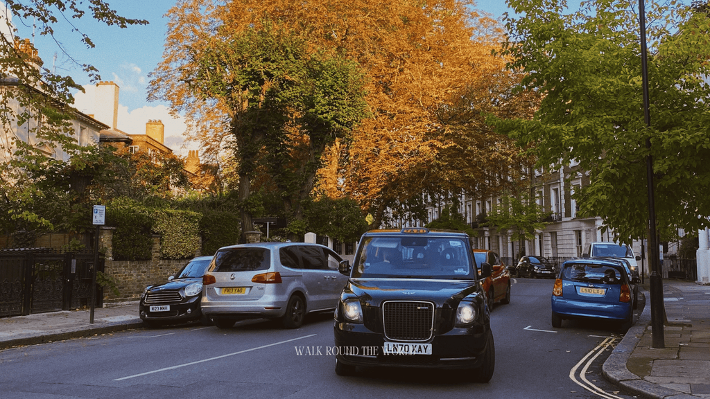 London street with a black taxi and autumn trees in London