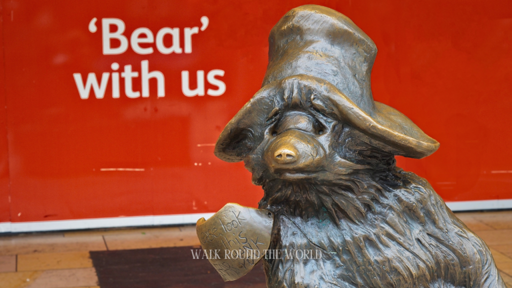 Paddington Bear statue with “Bear With Us” message written by Londoners